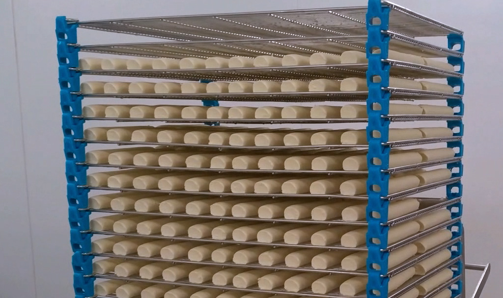 Mise en claies de bûches de fromage